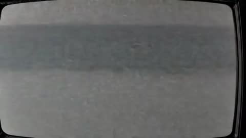 Vintage CRT Television Exhibiting Static Interference in Dim Light