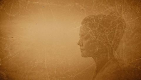 Sepia-washed contemplative female profile with distressed paper texture and copy space
