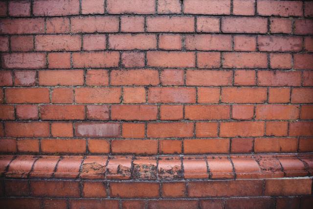 This image shows a red brick wall with a weathered texture, ideal for use in architectural designs, construction projects, or as a background for various creative works. The rustic and vintage appearance makes it suitable for themes related to urban settings, historical buildings, or industrial design.