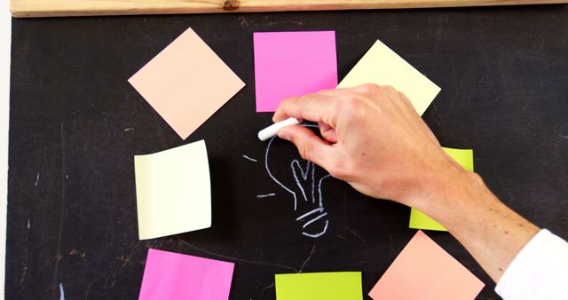 Hand Drawing Light Bulb on Chalkboard with Colorful Sticky Notes - Download Free Stock Images Pikwizard.com