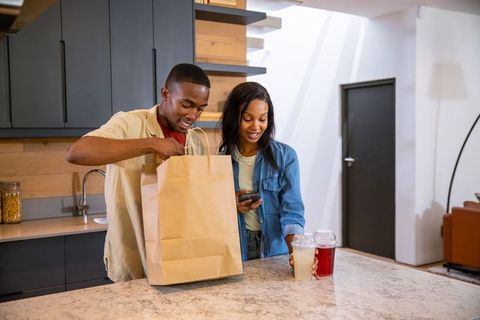 Couple Unpacking Groceries in Modern Kitchen Island Setting