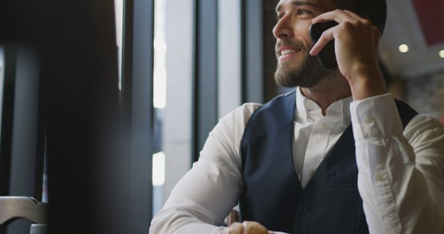 Smiling Businessman Wearing Vest Talking on Phone in Modern Office - Download Free Stock Images Pikwizard.com