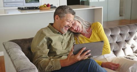 Senior Couple Enjoying Digital Content on Tablet in Cozy Living Room