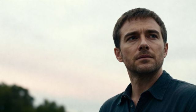 Contemplative man gazing at overcast sky with soft treeline and wide copy space