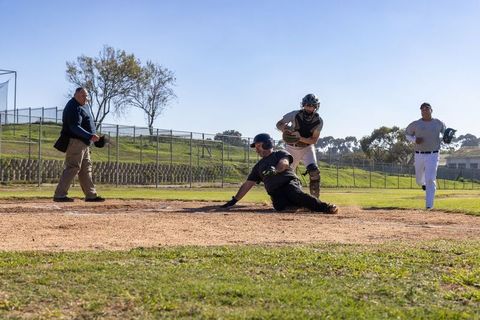 Sliding Baserunner Diving into Home Plate as Catcher Reaching to Tag During Local Baseball Game