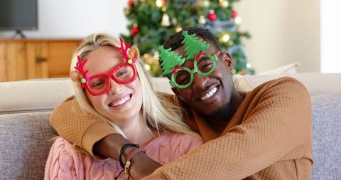 Cheerful couple wearing festive eyewear during holiday season