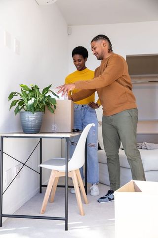 Couple unpacking boxes in bright minimalist apartment