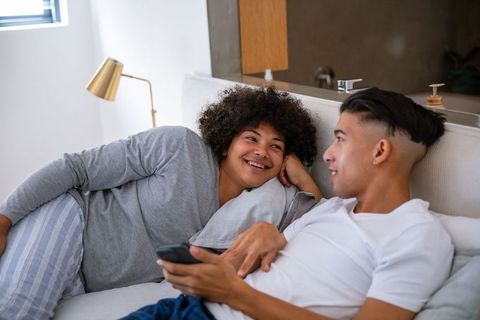 Diverse Male Friends Relaxing with Smartphone on Cozy Sofa