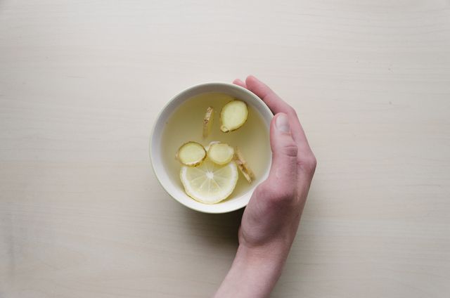 Hand Holding Cup of Lemon Ginger Tea on Light Background - Download Free Stock Photos Pikwizard.com