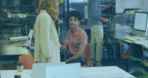 Young Man Listening While Collaborating in Tech Office with Data Visualization Overlay