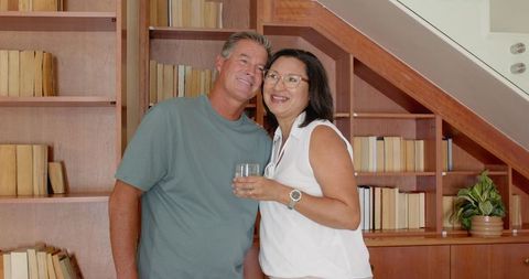 Happy Couple in Cozy Home Library with Wooden Bookshelves