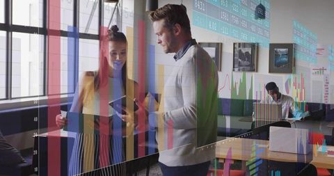 Colleagues collaborating with digital data in modern office setting