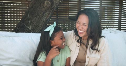 Mother and Daughter Sharing Laughter in Relaxing Outdoor Setting