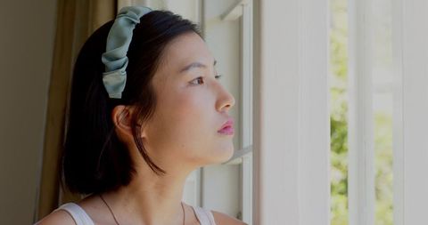 Woman Gazing out Window in Contemplation with Headband