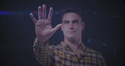 Man reaching with open palm against dark background with lens flares and moody lighting