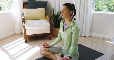 Woman Meditating in Sunlit Room with Modern Decor Elements
