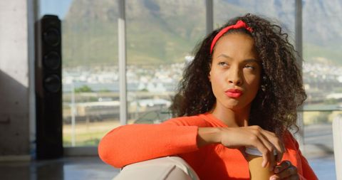 Thoughtful Young Woman in Bright Office Holding Coffee