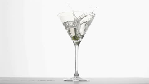 Olive Splashes Into Refreshing Martini Glass