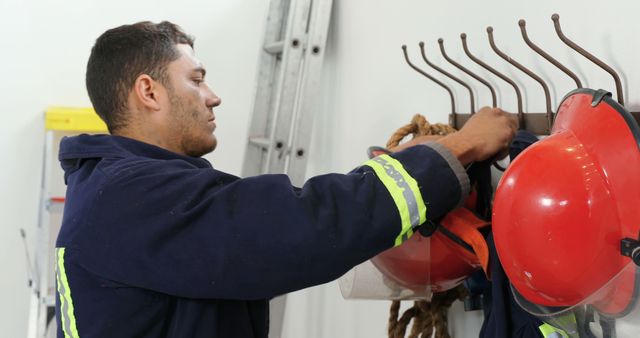 Firefighter Storing Gear on Hook in Firehouse - Download Free Stock Images Pikwizard.com