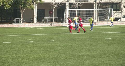 Youth Soccer Players Competing Passionately on Green Field