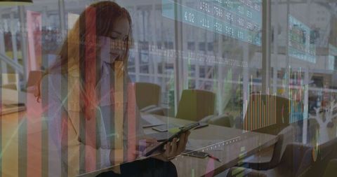 Professional Woman Analyzing Financial Charts on Tablet in Modern Office