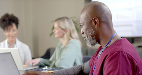 Diverse Healthcare Professionals Using Technology in Meeting Room