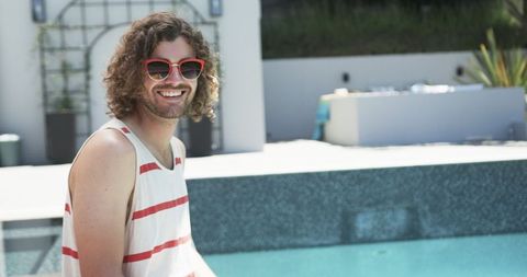 Smiling Young Man Enjoying Leisure by Poolside in Summer