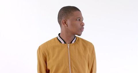 Confident Young Man in Stylish Yellow Jacket Against Minimalist Background