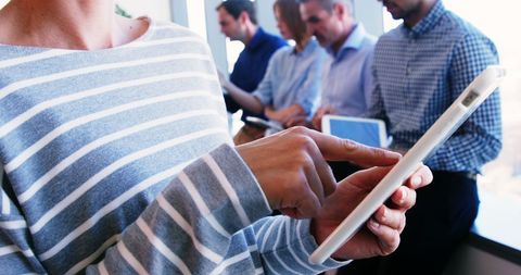 Casual professional using tablet in collaborative work meeting