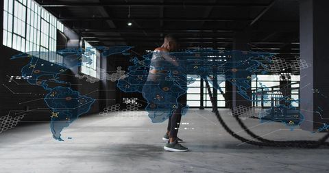 Fit man training with battle ropes in industrial warehouse with futuristic hud overlay