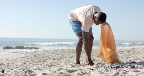 Man cleans beach for environmental efforts slow motion