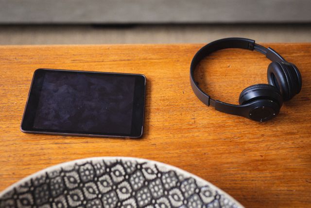 Close up view of digital tablet and headphones on a wooden table. technology and gadget concept