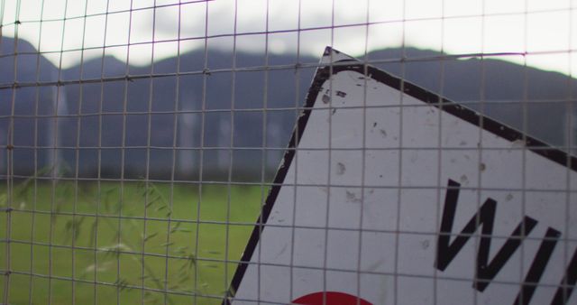 Tilted Warning Sign on Fence with Mountain Background - Download Free Stock Images Pikwizard.com