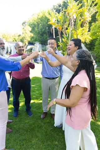 Multigenerational friends and family toasting with champagne at outdoor wedding