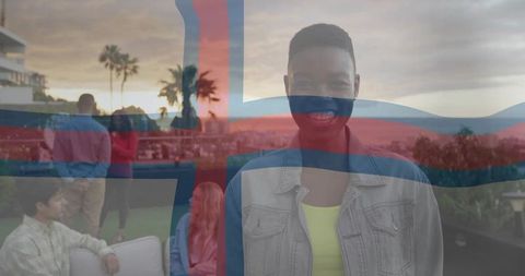 Smiling man at rooftop sunset gathering with friends