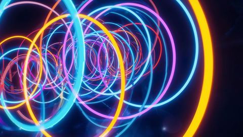 Spiraling neon rings forming glowing tunnel of multicolor concentric circles and light