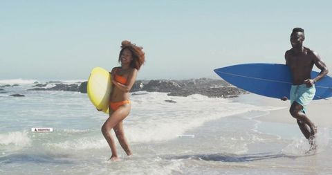 Surfers Enjoying Waves at Sunny Beach with Colorful Surfboards
