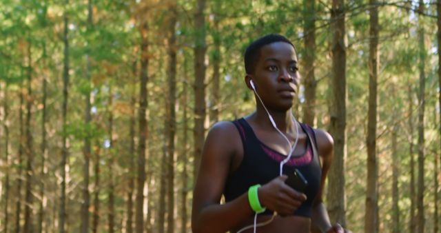 Woman Jogging with Earphones in Forest - Download Free Stock Images Pikwizard.com