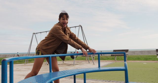 Joyful Young Girl Playing at Playground by the Beach - Download Free Stock Images Pikwizard.com