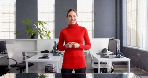 Businesswoman in Red Sweater Presenting in Modern Office