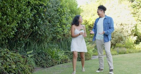 Couple Enjoying Romantic Walk in Garden Holding Flower