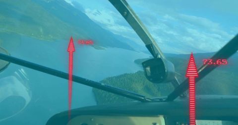 Cockpit view of aircraft flying over mountain lake with hud indicators