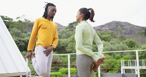 Diverse friends stretching on rooftop terrace during outdoor wellness workout