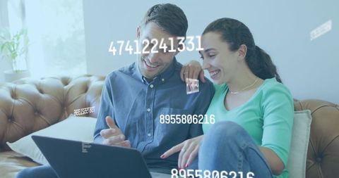 Happy couple using laptop with digital overlay