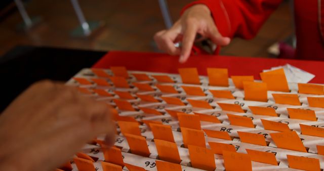 Hands selecting origami fortune slips at Japanese temple. Great for websites related to travel, cultural traditions, tourism, spirituality, and traditional practices.