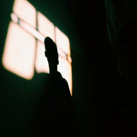 Person silhouette with dramatic shadow on wall