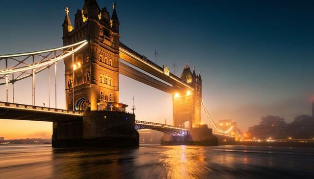 Golden twilight illuminating tower bridge and river thames reflections at dusk