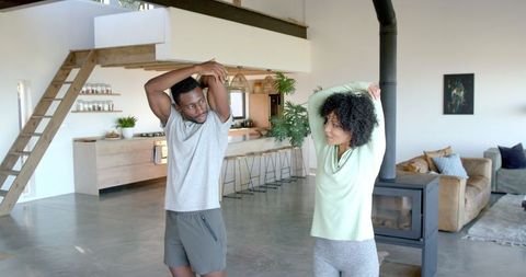 Happy Couple Stretching at Home in Modern Living Room