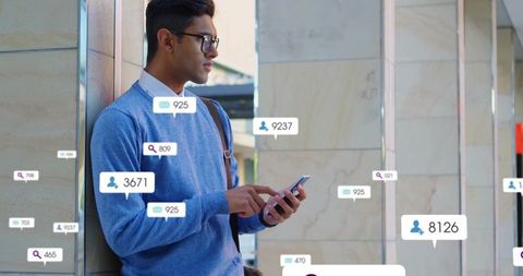 Young professional leaning on marble column checking smartphone with floating social notifications