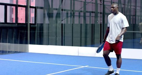 Energetic Young Man Playing Padel on Modern Urban Court